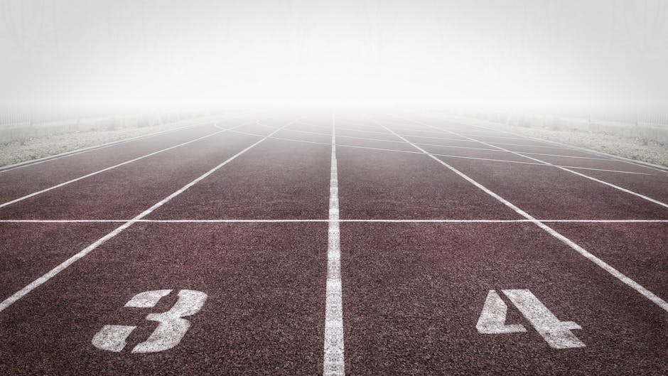 A foggy track field with visible lane numbers and white lines.