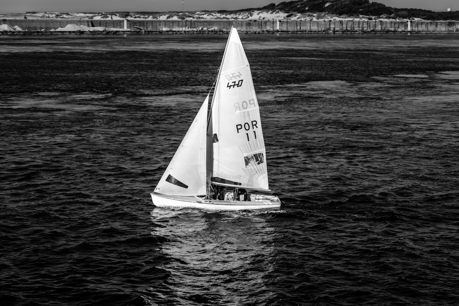 Monochrome image of a sailboat navigating the ocean, evoking adventure and freedom.