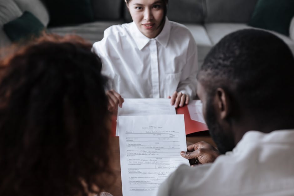 Three people reviewing documents in an office setting, focusing on adoption paperwork.