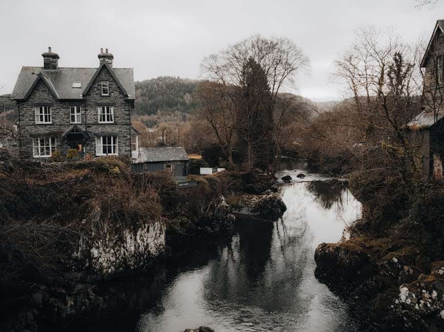 Picturesque old stone house by a tranquil river in Betws-y-Coed, Wales.