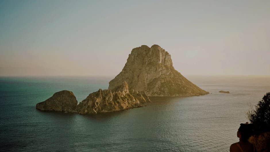 Scenic view of the mystical Es Vedra rock formation off the coast of Ibiza, Spain, during sunset.