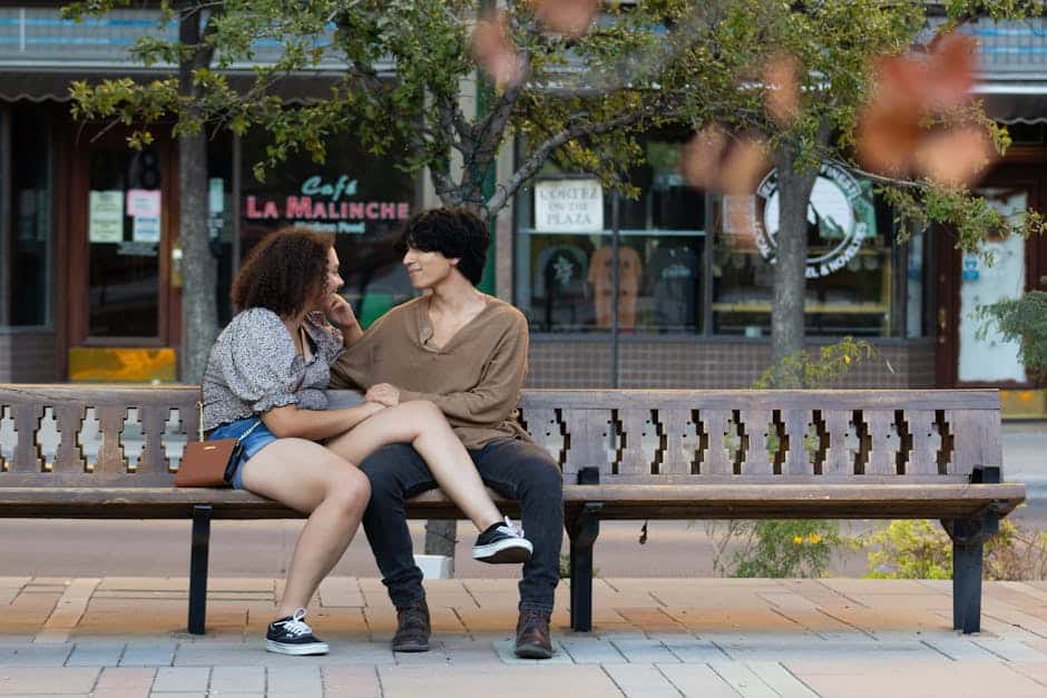 A couple shares a moment of affection on a bench in El Paso's lively streets.