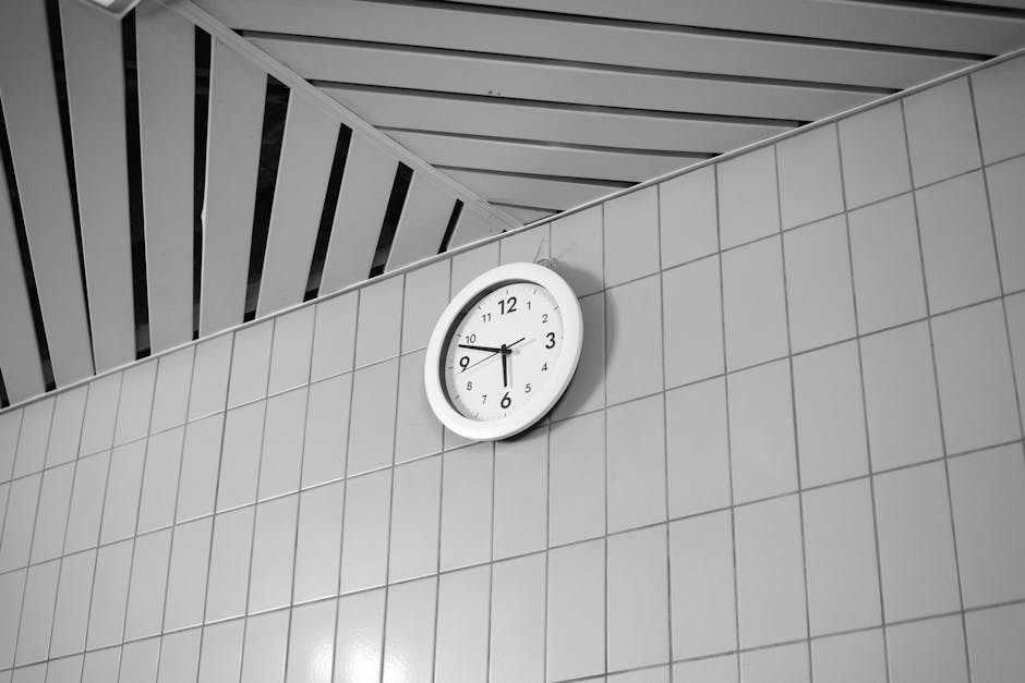 A black and white wall clock displays time on a tiled wall, creating a modern aesthetic.