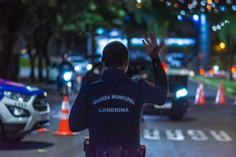 Municipal guard officer managing traffic in Londrina, Brazil at night.