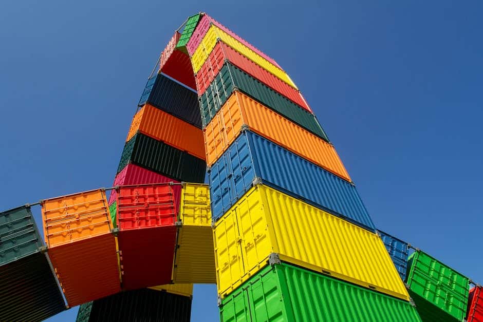 Vibrant stacked shipping containers forming an artistic sculpture under a clear blue sky.
