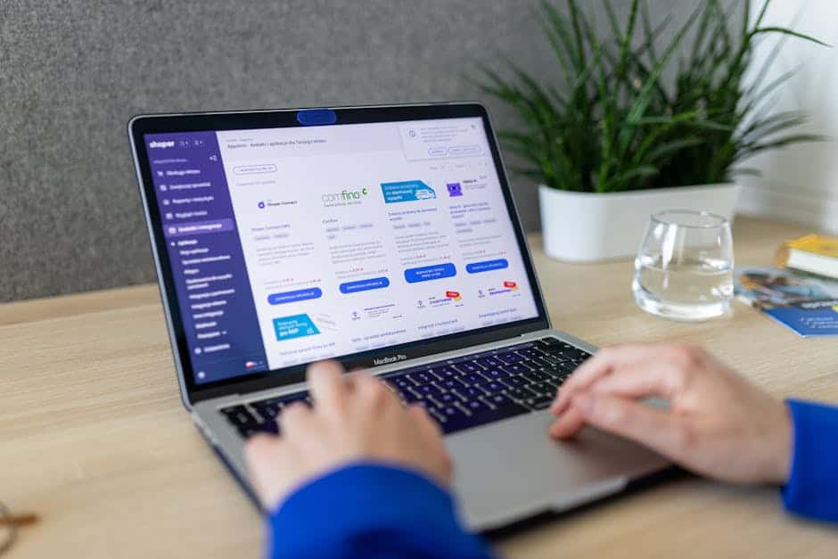 Close-up of hands on a laptop browsing an e-commerce site in a modern office.