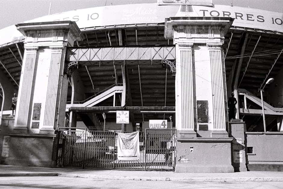 Black and white photograph of the iconic Baseball Stadium entrance in Mexico City, highlighting its architectural details.